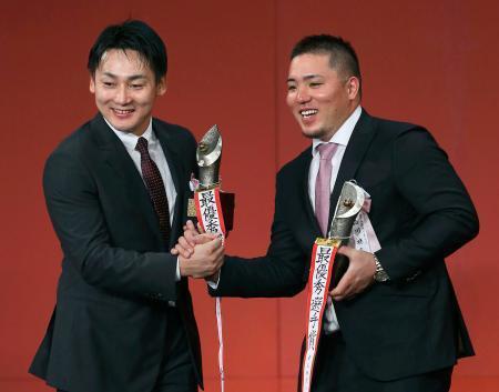 　ＭＶＰを受賞し、笑顔で握手を交わす広島・丸（左）と西武・山川＝２７日、東京都内のホテル