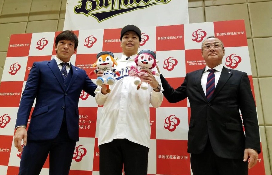 　仮契約を終えた育成１位の漆原、左は牧田チーフスカウト