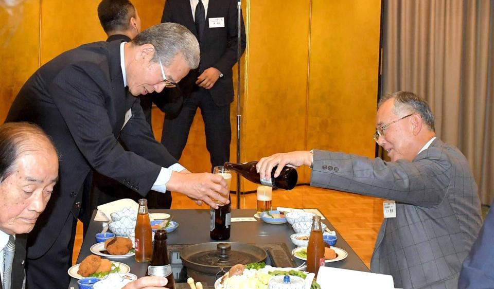 　山田ＯＢ会会長（左）にビールを注ぐ宮内オーナー