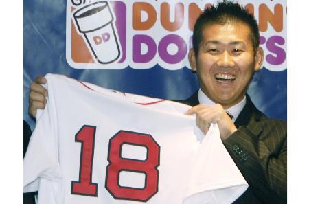 　２００６年、大リーグのレッドソックスの入団記者会見で、背番号「１８」のユニホームを手に、笑顔の松坂＝ボストン（共同）