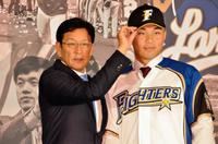 ユニホームに袖を通した王柏融