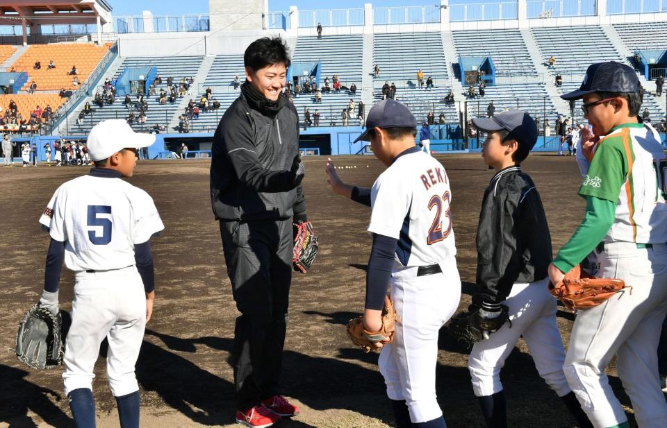 子供たちとハイタッチするオリックス・竹安大知＝静岡・草薙総合運動場（撮影・佐藤厚）