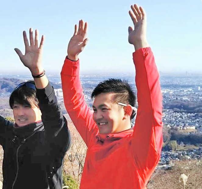 　山頂で笑顔を見せる山崎康