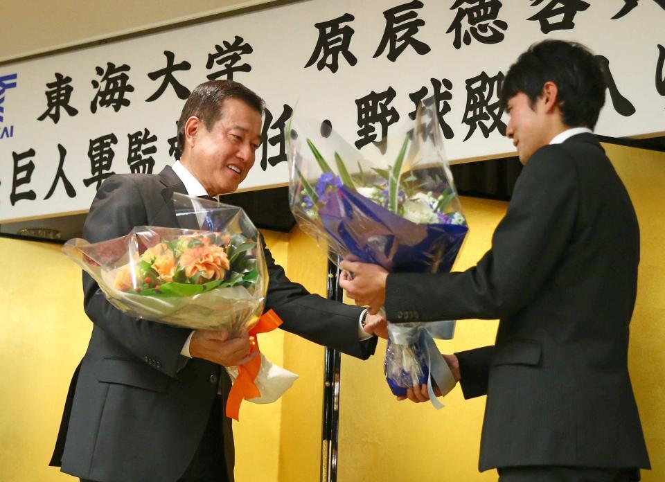 　野球殿堂入りを祝う会で箱根駅伝を制した湊谷主将（右）から花束を贈られる原監督