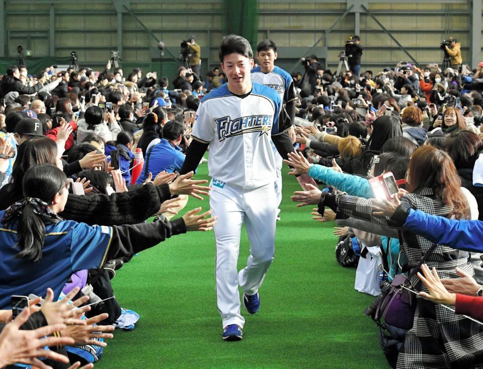 　新入団選手歓迎式典でファンとタッチをしながら入場する吉田輝