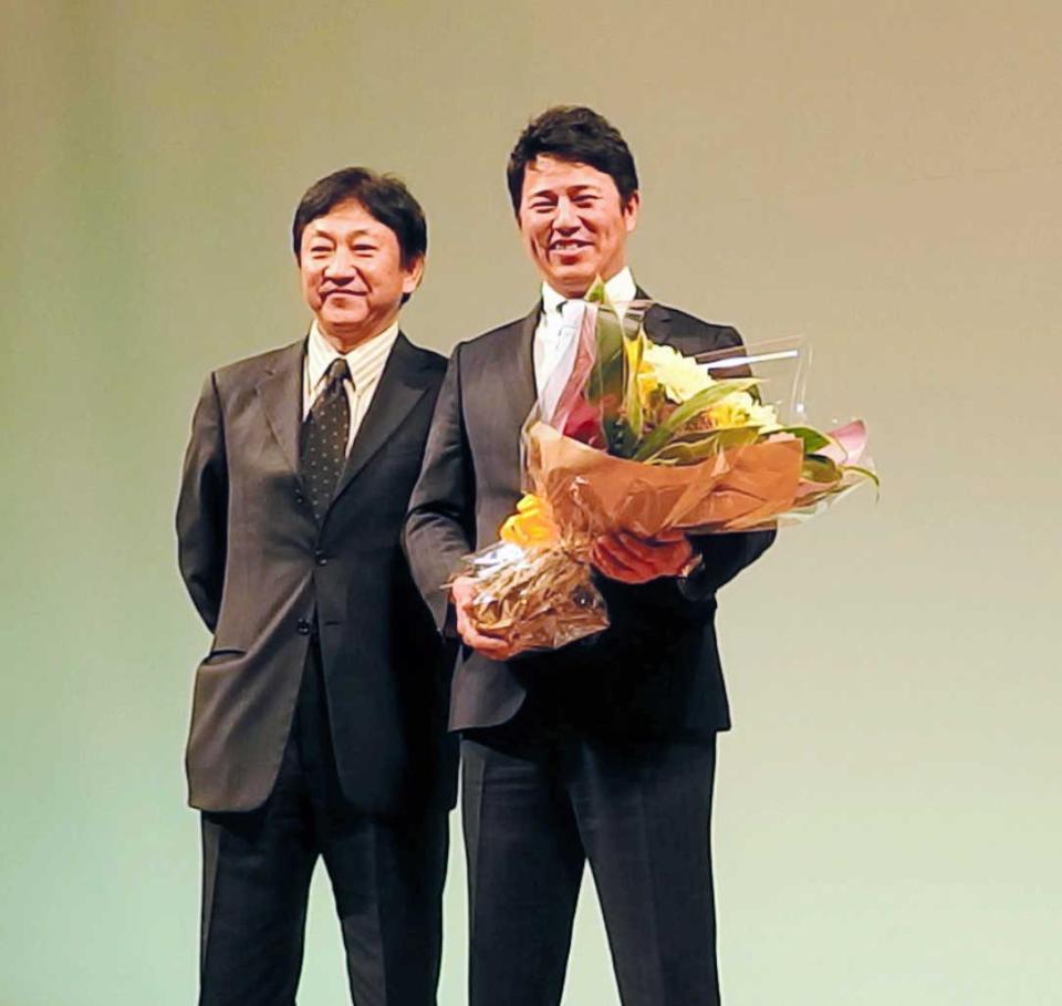 　大学の先輩・田尾氏から花束を贈られた平石監督（右）