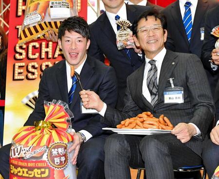 　ウインナーソーセージを食べるポーズをする吉田輝（左）と栗山監督（撮影・出月俊成）