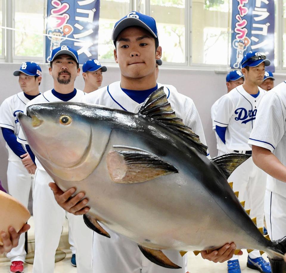 　歓迎セレモニーの特産品贈呈でマグロの模型を抱える根尾（撮影・開出牧）