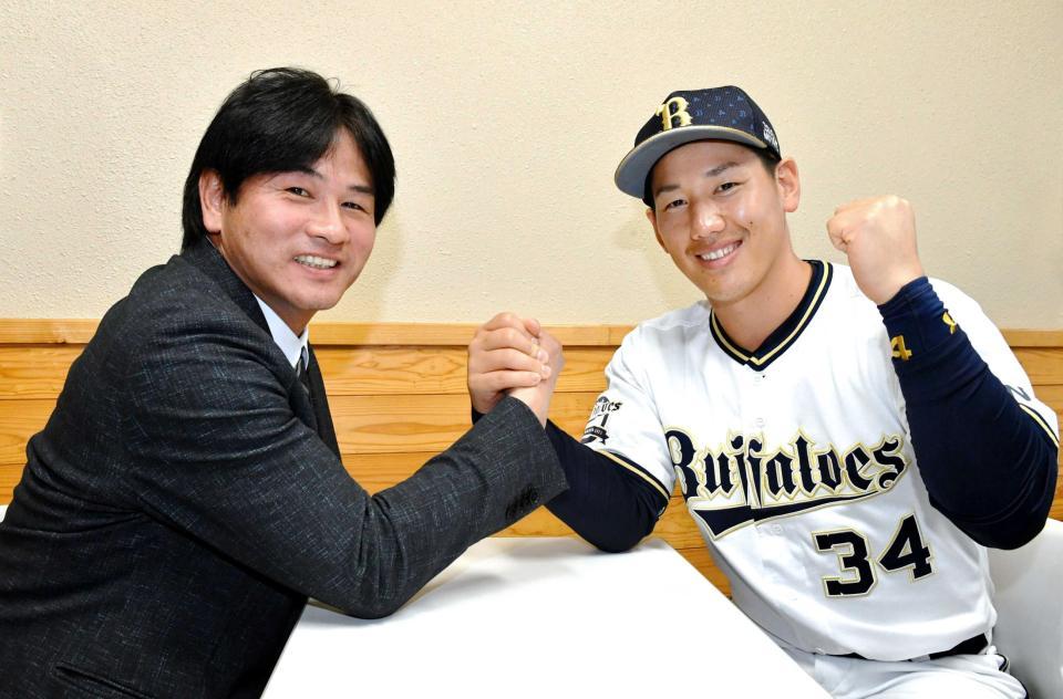 　笑顔で握手を交わす吉田正（右）と本紙評論家の谷佳知氏