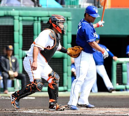 １回、空振り三振を喫した中日・平田良介（右）にタッチする巨人・阿部慎之助＝沖縄セルラースタジアム那覇（撮影・棚橋慶太）