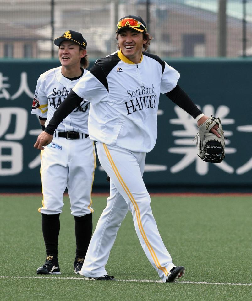 　守備練習中、笑顔を見せる内川。左は牧原