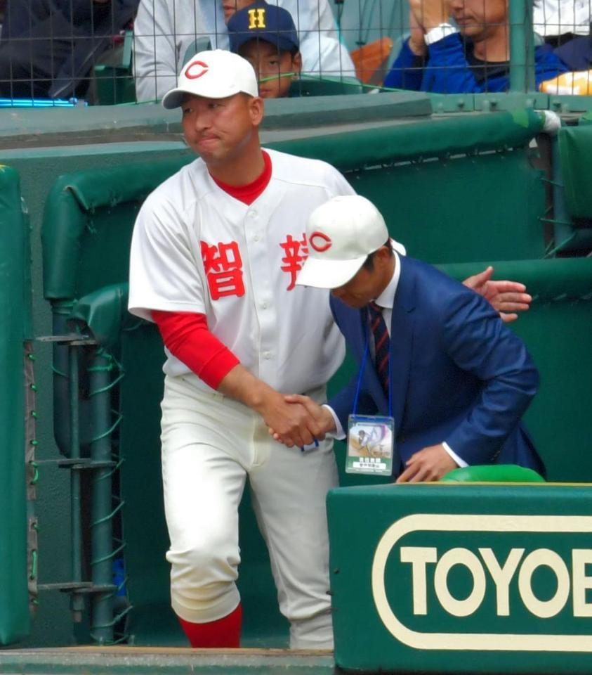 熊本西に勝ち、ベンチで握手し勝利を喜ぶ智弁和歌山・中谷仁監督（左）＝甲子園球場（撮影・吉澤敬太）