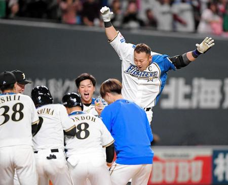 　延長１０回、サヨナラ満塁本塁打を放ち、ナインが待つ本塁へ飛び込む中田（撮影・棚橋慶太）