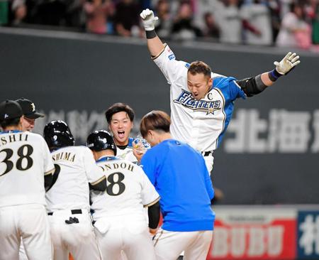 　延長１０回、サヨナラ満塁本塁打を放ち、ナインが待つ本塁へ飛び込む中田＝２９日