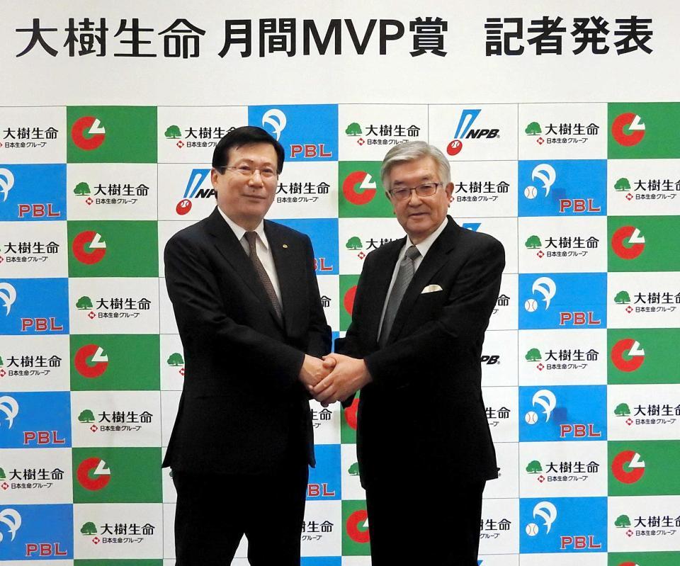 　握手を交わす大樹生命保険株式会社の吉村俊哉代表取締役社長（左）とＮＰＢの斉藤惇コミッショナー