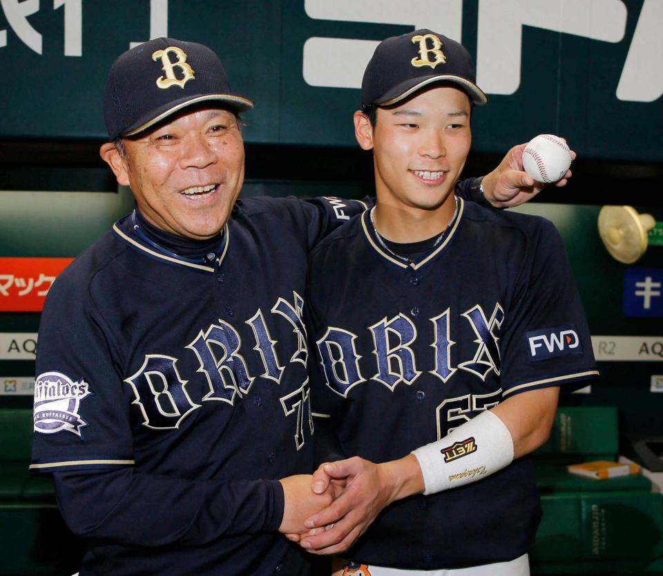 　監督通算２００勝を挙げ、記念球を手に中川（右）とポーズをとる西村監督