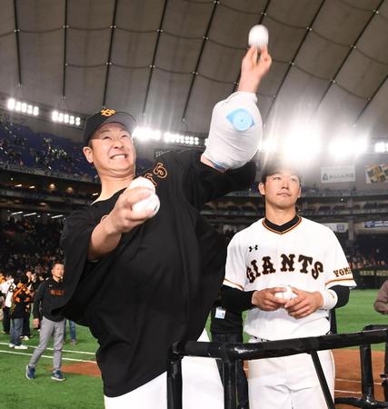 サインボールを投げ入れる中川皓太（左）と山本泰寛＝４月２７日