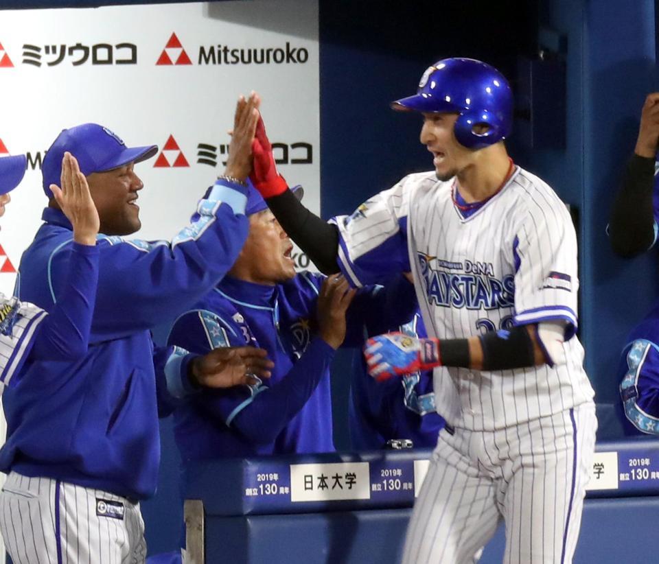 ６回、満塁本塁打を放った伊藤光（右）を迎えるＤｅＮＡ・ラミレス監督＝横浜スタジアム