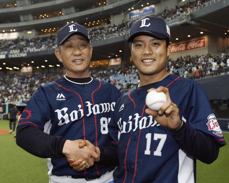 　オリックス戦でプロ初勝利を挙げ、記念球を手に辻監督（左）と握手する松本航