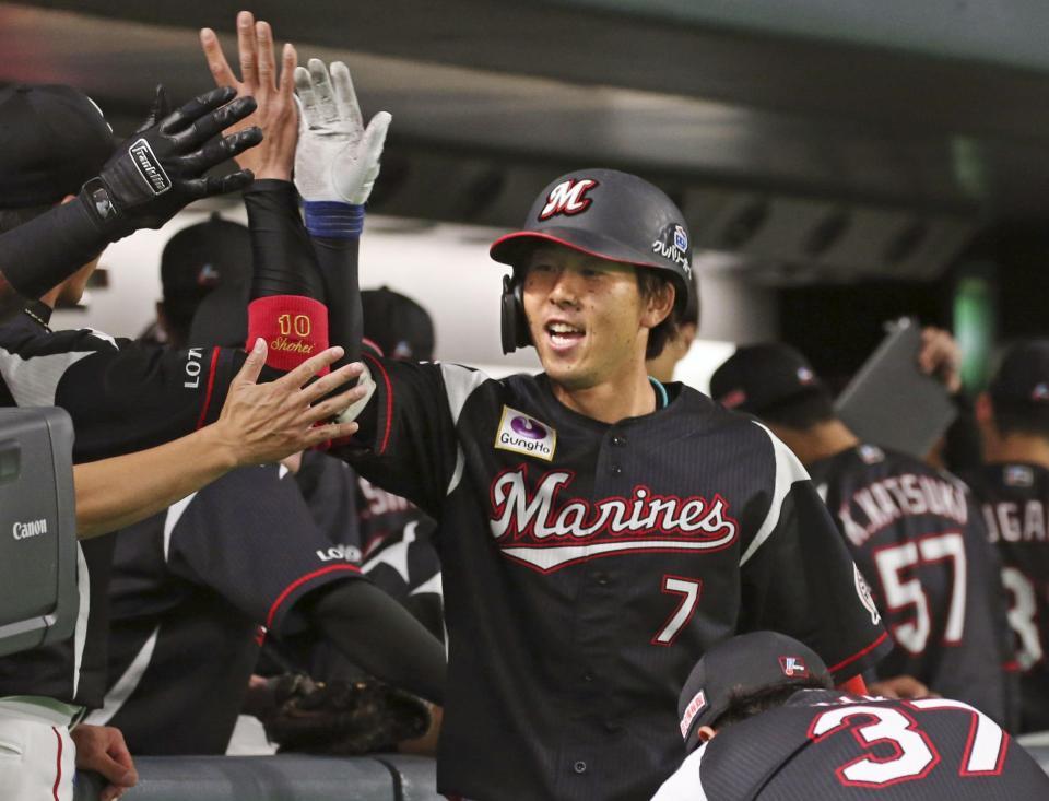 　１回、先制ソロを放ち、ナインに迎えられるロッテ・鈴木＝札幌ドーム