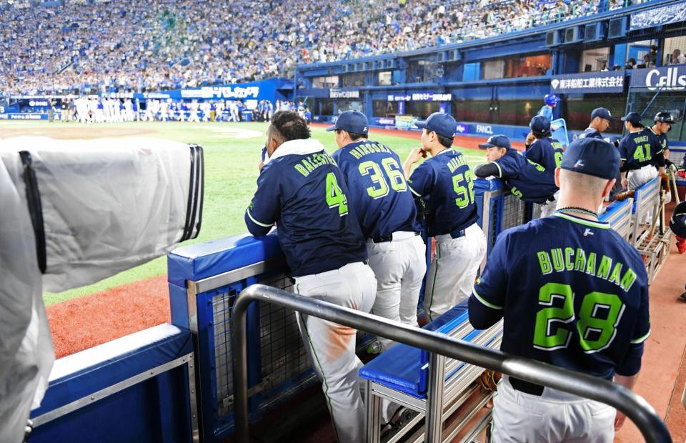 　一塁ベンチ前でハイタッチするＤｅＮＡナインをみつめるヤクルト・バレンティン（左端）ら