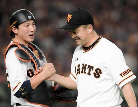 ８回、堂上を併殺打に打ち取り、小林（左）と握手を交わし笑顔の沢村