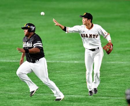 　１回、三塁へ悪送球する巨人・坂本勇人（右）＝東京ドーム