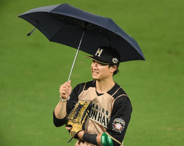 【写真】雨の球場　選手も折り畳み傘持参で守備位置に就いちゃった