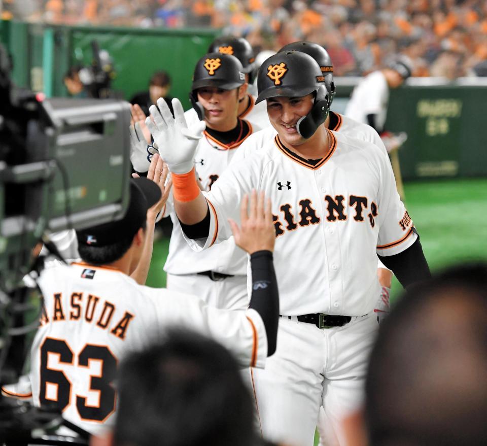 １回、満塁弾を放ち、ナインと笑顔でタッチを交わす巨人　アレックス・ゲレーロ（右）＝東京ドーム（撮影・出月俊成）