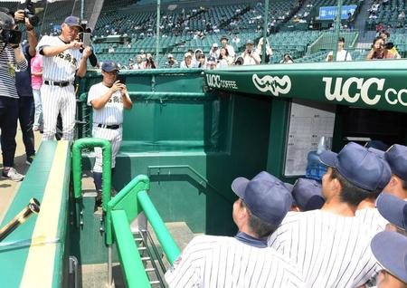 　選手をスマホで撮影する明石商・狭間監督（左）