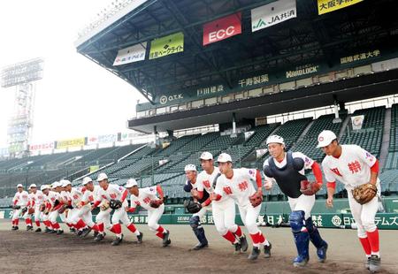 　勢いよくグラウンドに駆け出す智弁和歌山ナイン