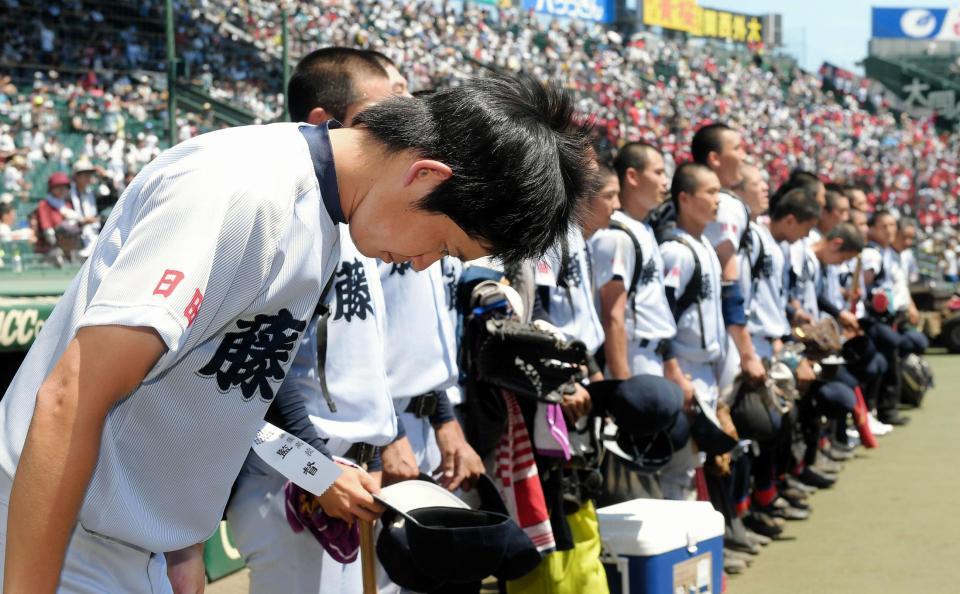 　明徳義塾に敗れ、選手らとグラウンドに一礼する藤蔭・竹下監督（左端）＝甲子園