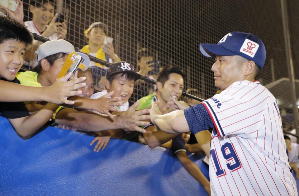 　８回１失点で６勝目を挙げ、観客とタッチを交わすヤクルト・石川＝神宮