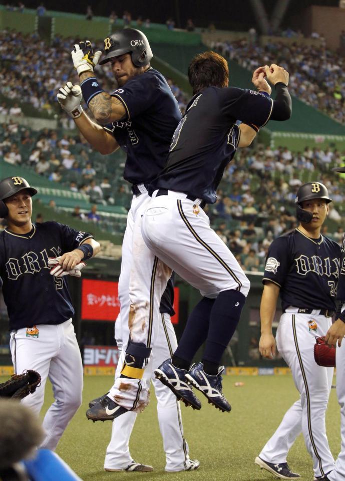 ３回、満塁本塁打を放ち、安達（右）とジャンプして喜ぶオリックスのロメロ＝メットライフドーム