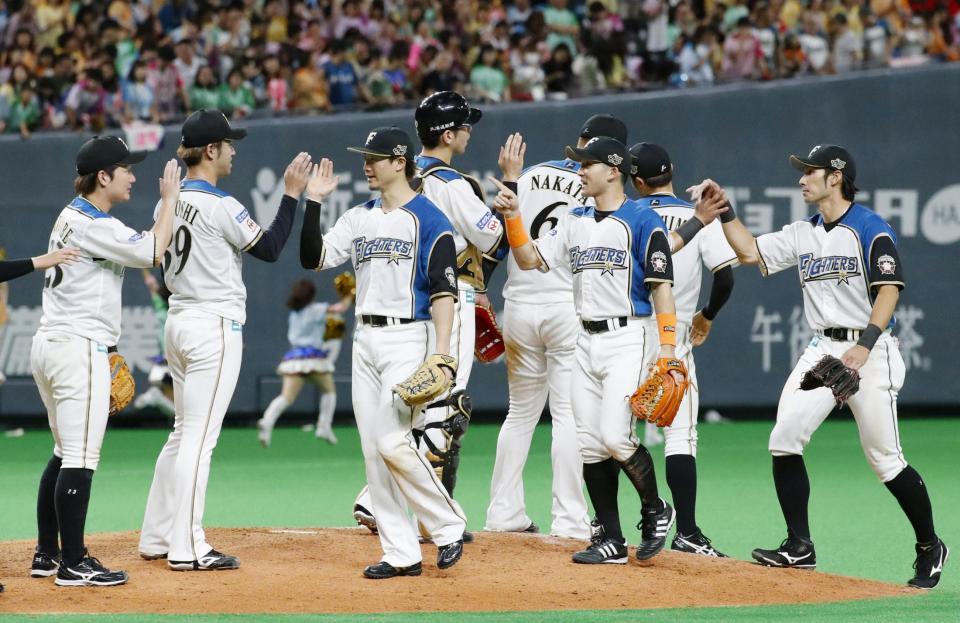 ソフトバンクに勝利し、タッチを交わす日本ハムナイン＝札幌ドーム