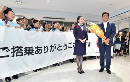 　「福岡空港に到着し、航空会社職員から花束を受ける工藤監督（右）