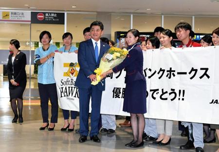 　福岡空港に到着し、花束を受け取る工藤監督（中央左）