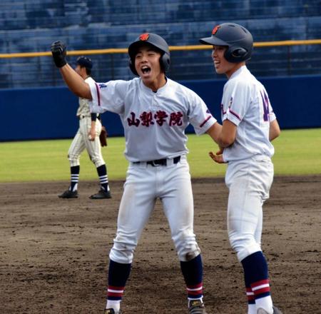 　９回、逆転の２点適時内野安打を放ち、ガッツポーズする山梨学院・外川（左）