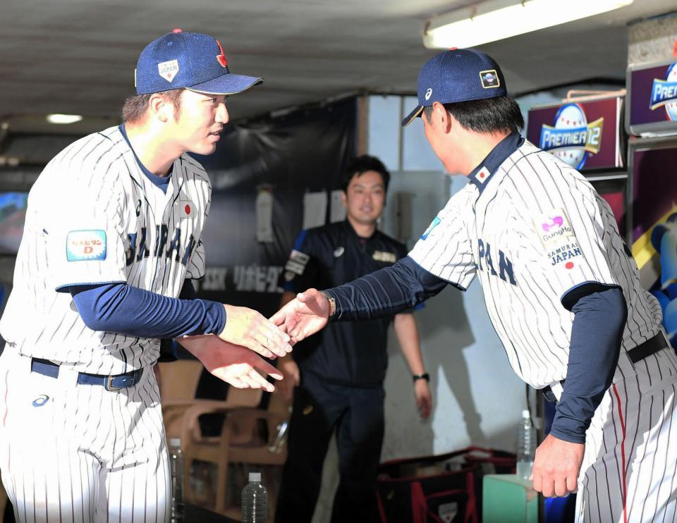 日本代表・稲葉篤紀監督（右）と握手を交わす広島・鈴木誠也＝台湾・桃園国際野球場（撮影・中田匡峻）