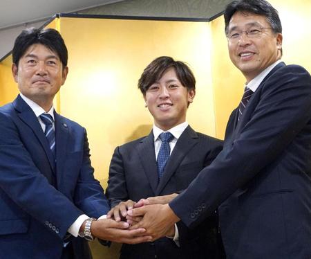 　入団が決まり、日本ハムの大渕スカウト部長（右）らと握手するＪＦＥ西日本の河野竜生投手（中央）＝11日、広島県福山市