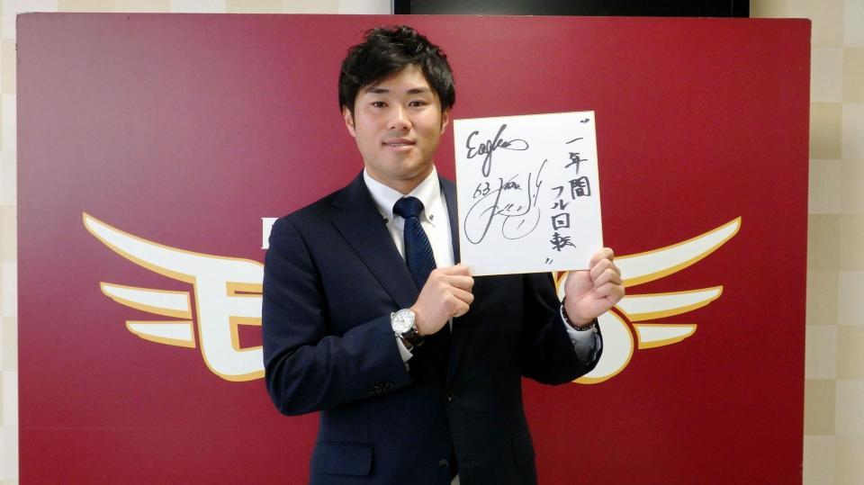 契約を更改し、来季の目標を色紙に記した楽天・由規＝仙台市内の球団事務所