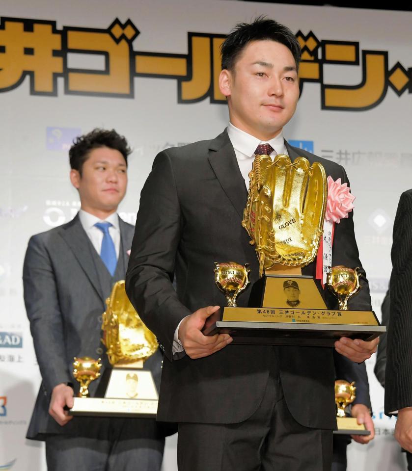 　三井ゴールデン・グラブ賞を受賞した巨人・丸。後方左は坂本勇＝都内のホテル