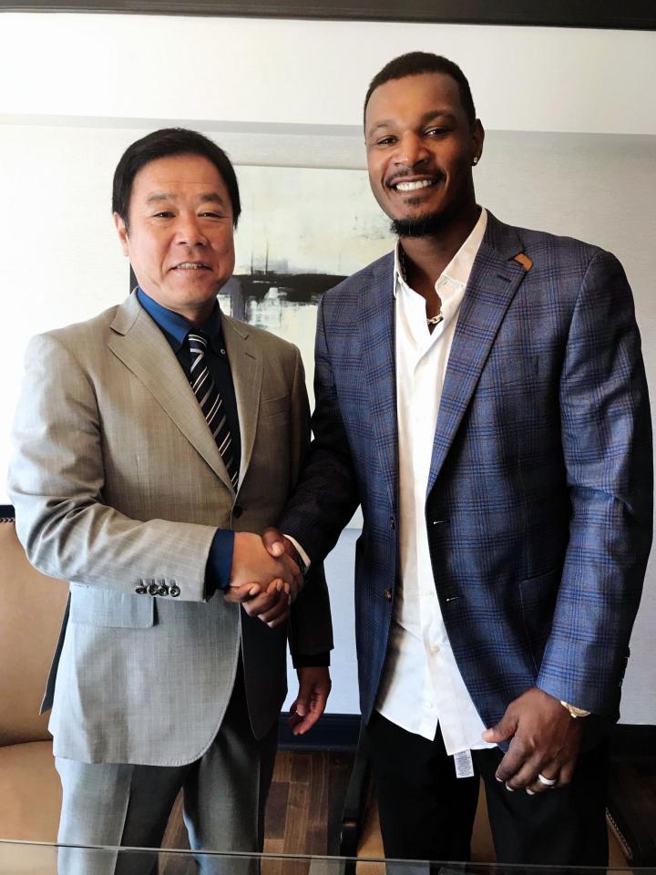 契約合意し福良ＧＭと握手するアダム・ジョーンズ（球団提供）