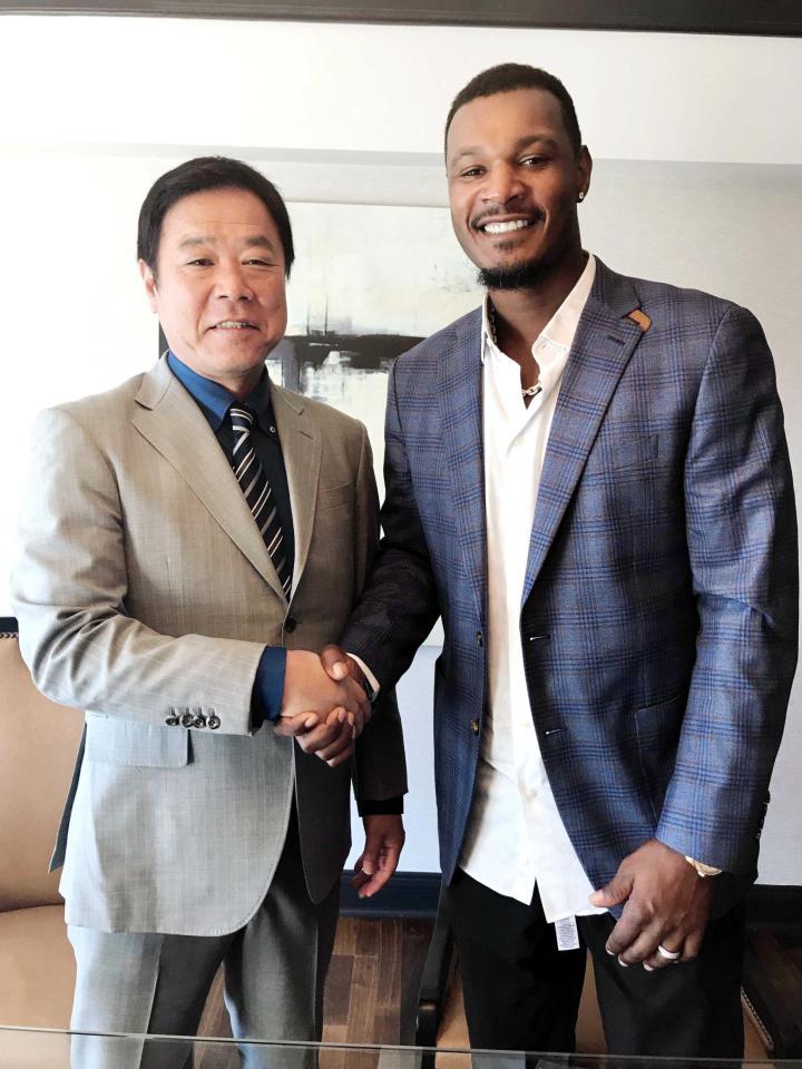 　契約合意し福良ＧＭと握手するアダム・ジョーンズ（球団提供）