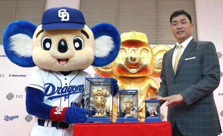 　純金製ドアラを中央に山本昌さん（左）とドアラ