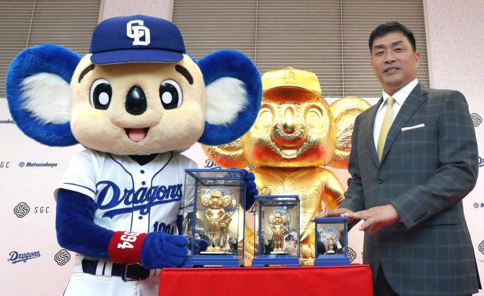 　純金製ドアラを中央に山本昌さん（左）とドアラ