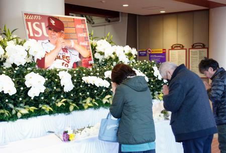　楽天生命パーク宮城に設置された野村克也元監督の献花台に手を合わせる人たち＝１２日午前、仙台市