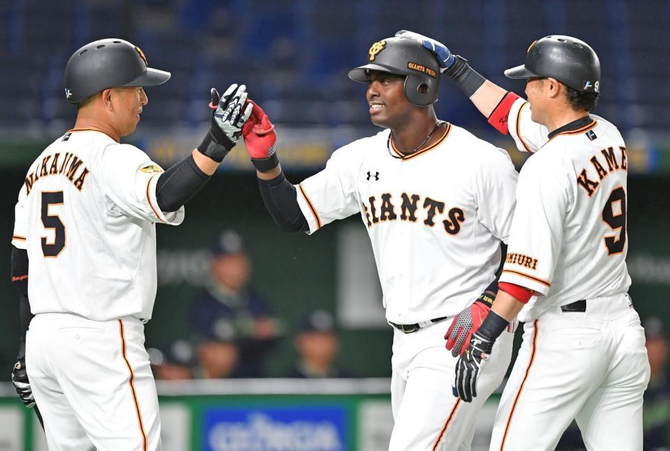 　４回、先制２ランを放ち、中島（左）と亀井（右）に祝福されるモタ（撮影・西岡正）
