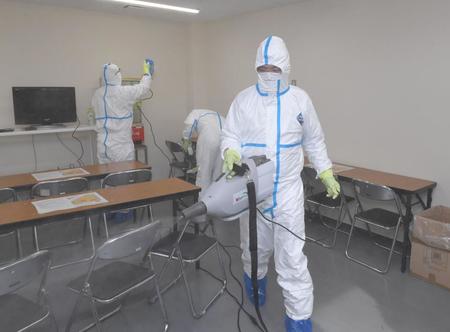 　鳴尾浜のプレスルームを消毒する作業員ら＝３月２６日