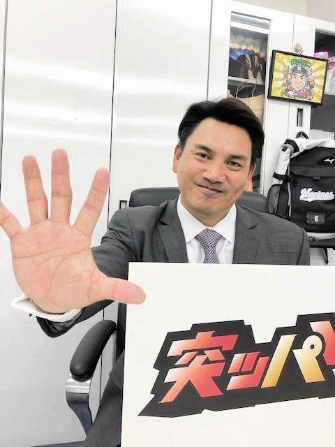 　今季のチームスローガン「突ッパ」のボードを手に持つ井口監督（球団提供）